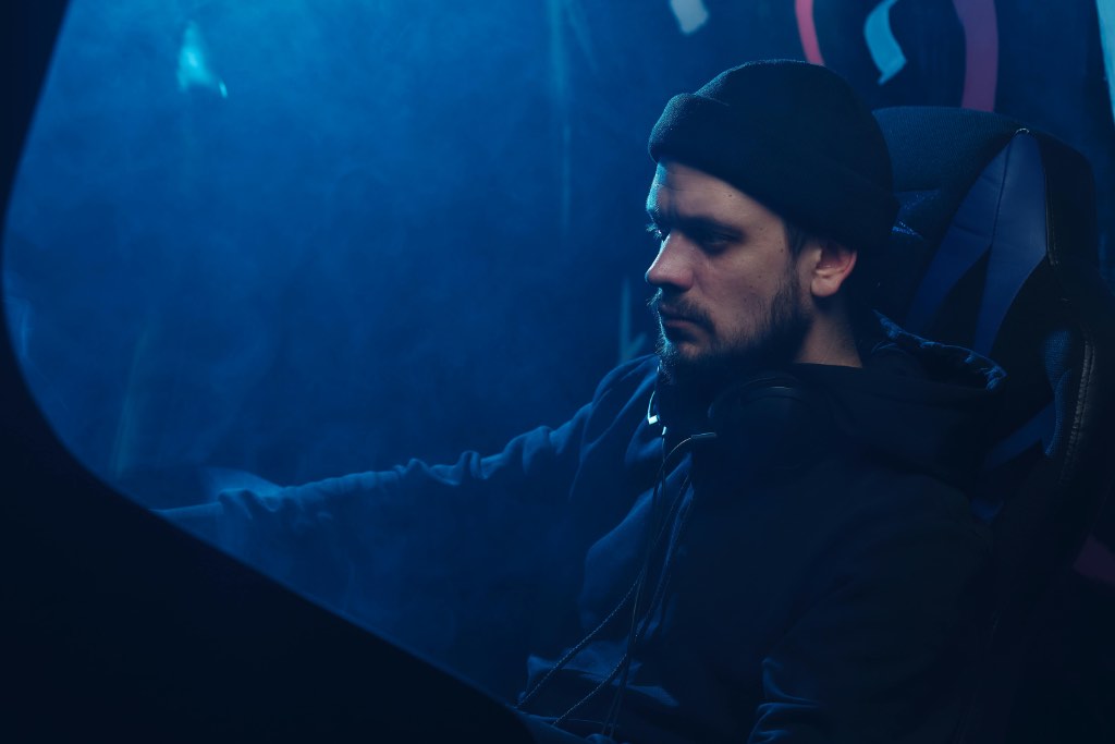 Kuvitteellinen kyberrikollinen istumassa hämyisessä luolassaan.